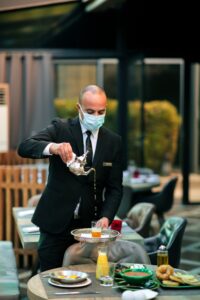 a man in restaurant poring tea in a glass